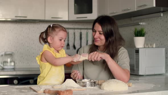 Cheerful Mother and Daughter are Fooling Around While Cooking Pastries From Dough alt