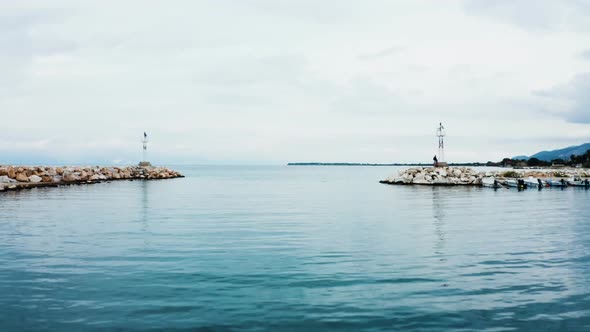 Drone Flying Over Turquoise Sea Water Leaving the Harbor alt