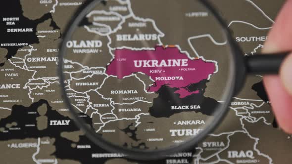 Ukraine on the World Map Under Magnifying Glass alt