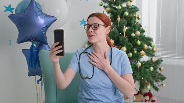 Congratulations Online a Young Woman in Glasses with a Phonendoscope in Medical Clothes alt