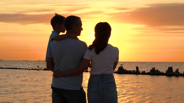 Teamwork. Silhouette of a Happy Family Against the Background of the Sunset. Father, Mother and alt