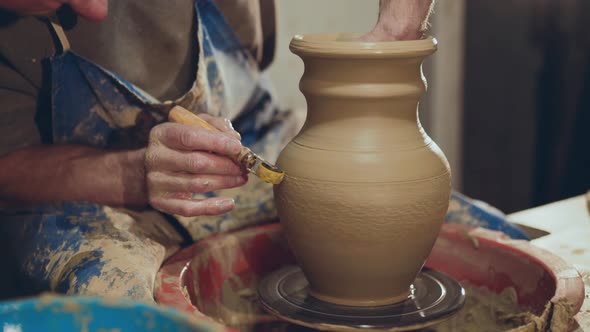 The Potter Making Pattern on Clay Vase Using Tool for It alt