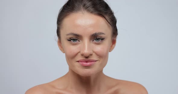 Portrait of Beautiful Woman with Happy Emotion Looking at Camera at Gray Background
