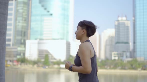 Young woman running in city park.