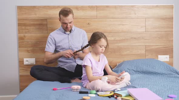Father Making Braids to Little Girl in Morning at Home