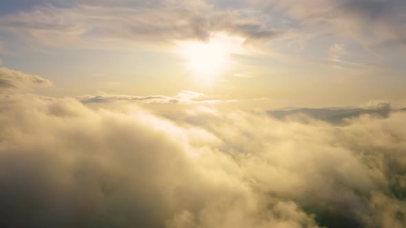Flying above clouds at Sunset. Beautiful aerial Cloudscape. Concept: Religion, afterlife alt