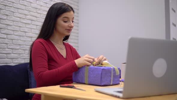 Attractive Woman Prepare Gifts Talking By Video Call Handmade Wrapping Present