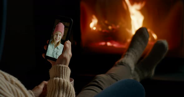 Woman Makes Online Video Call By Smartphone in Cozy Room with Fireplace