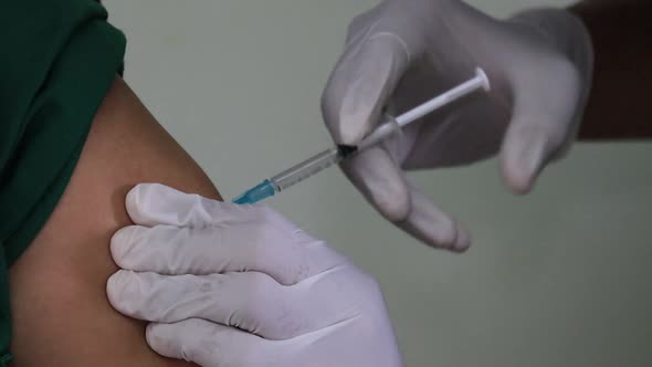  injecting the Covid 19 vaccine into the patient's body