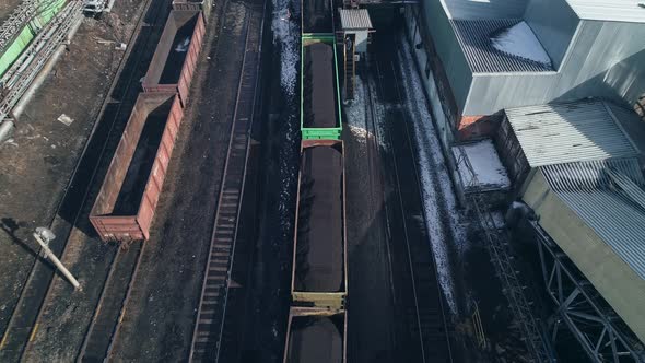 Industrial Railroad Cars Stand in Coal Port During Loading of Raw Materials