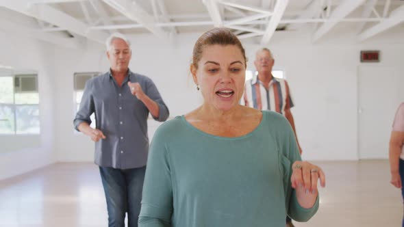 Caucasian senior male and female friends spending time together in a ballroom and dancing alt
