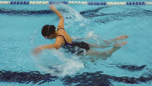 Woman Amateur Swimmer Performing Butterfly Stroken In Swimming Pool