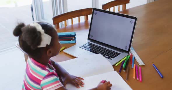 African american girl having online learning at home using laptop with copy space alt