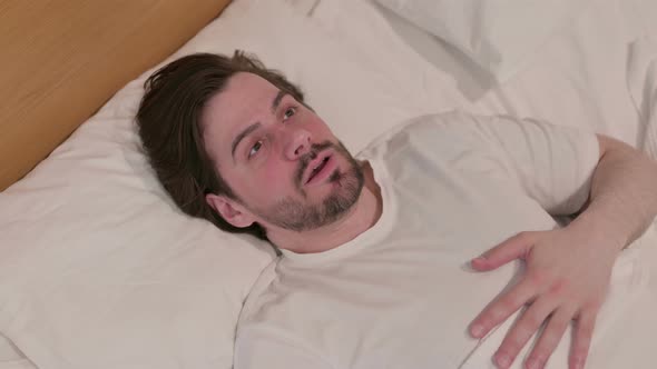 Casual Young Man Waking Up From Nightmare in Bed alt