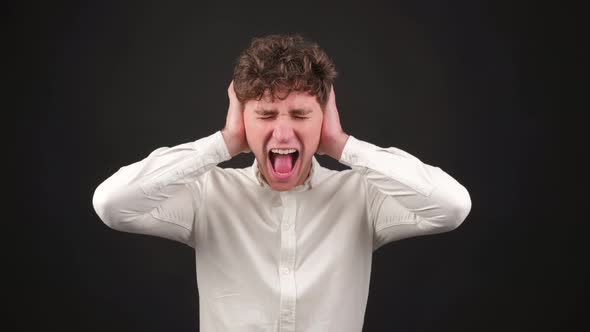 Young Stressed Man Covering Ears with Hands Screaming Shouting alt