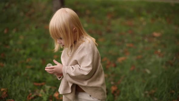 Happy Cute Baby Girl Running Around the Autumn Park