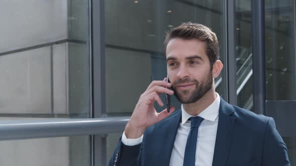 Businessman Answering Smartphone And Smiling alt