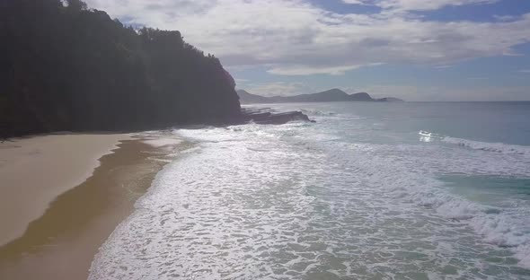 Spectacular aerial morning flight towards dark cliffs and stormy ocean, Australia alt