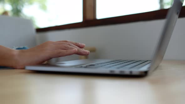 Closeup a woman working and touching on laptop computer touchpad on the table