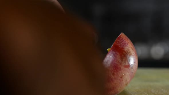 Close up shot of person cutting a passion fruit in two pieces on wooden table alt
