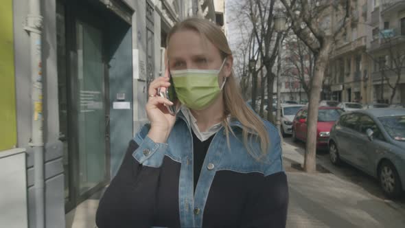 Woman in Mask Talking on Mobile Outdoor
