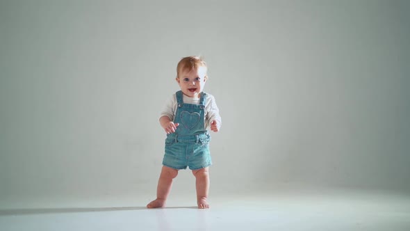 the child takes the first steps; he succeeds, but hesitates. studio slow motion alt