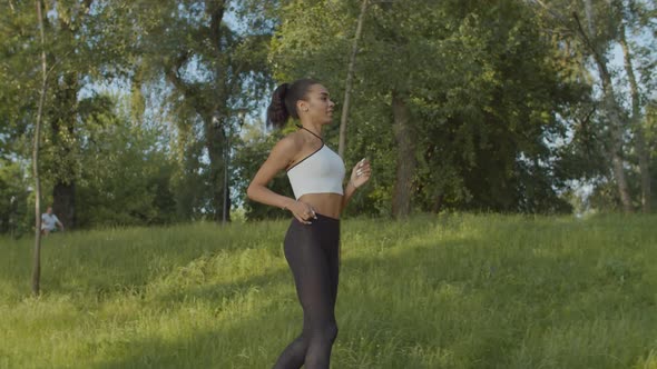 Black Female Jogger Running in Public Park at Dawn alt