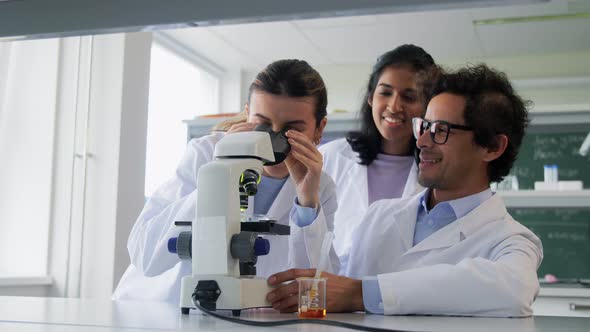 Scientists with Microscopes Working in Laboratory