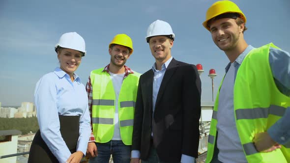 Professional Construction Team Showing Thumbs Up Gesture Smiling on Camera