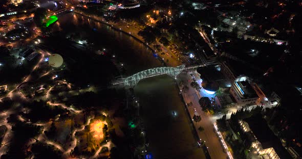 Night aerial view of Bridge of Peace and beautiful cityscape in the center of Tbilisi, Georgia 2022 alt