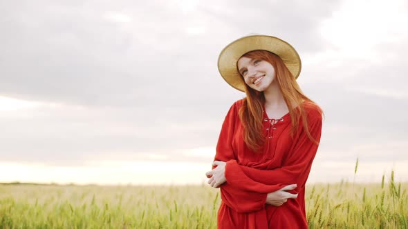 Slow Motion of Redhead Beautiful Girl Feeling Romantic and Happy Standing in Middle of Wheat Field