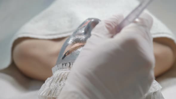 Young Woman Getting Beauty Cosmetic Treatment, Close-up. Top View. Beautician Hands at Work alt