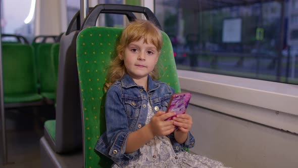 Girl Playing on Smartphone Chatting Texting Browsing Social Media While Traveling By Tram to City alt