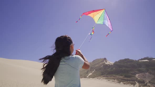 Young girl flying kite at beach