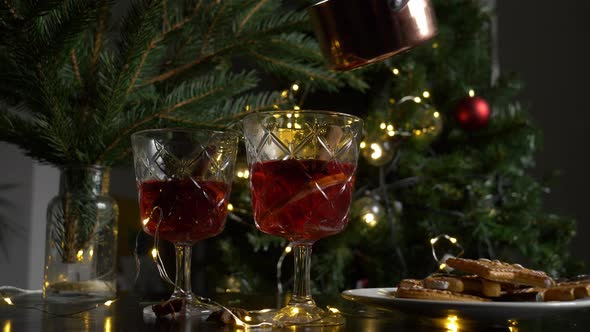 Two glasses with mulled wine near cookies in a table