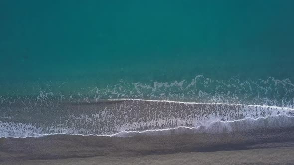 Top Down View Turquoise Waves Reaching Shore Break on Empty Pebble Beach. Pure Sea From Bird's Eye alt