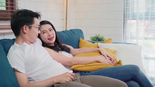 Asian couple hug together in living room at home, sweet couple enjoy love moment