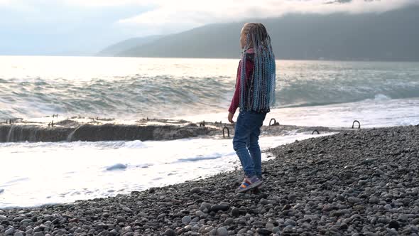 Little Girl Watching Stormy Waves on the Beach alt