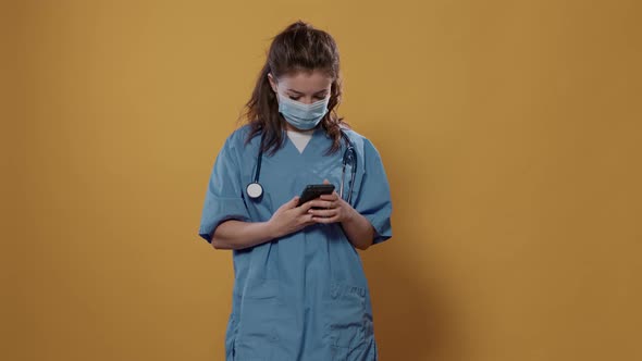 Doctor with Stethoscope Holding Smartphone and Texting Showing Green Screen Mockup alt