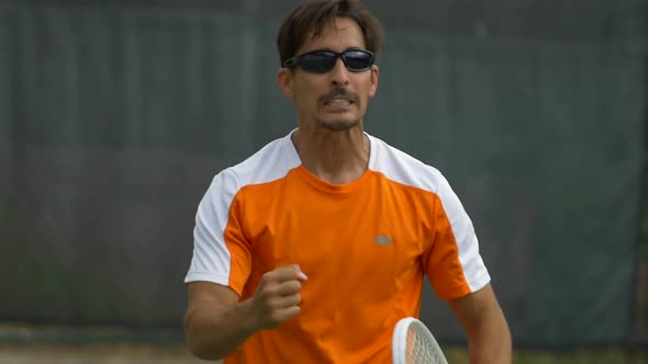 Tennis player celebrating after a good set. alt