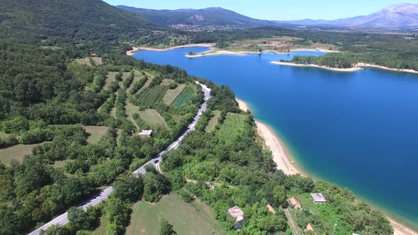Aerial view of red van driving on dalmatian highway by artificial lake Peruca alt