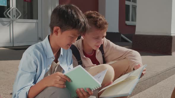 Boys Doing Homework on Steps of School Building alt