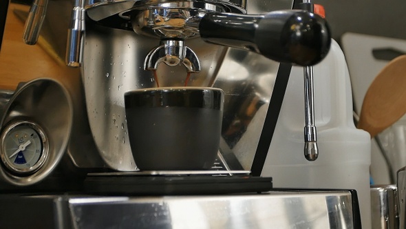 Espresso pouring into a cup from professional machine