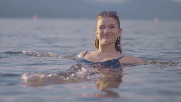 Beautiful girl swimming away backwards alt