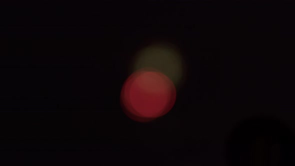 Wide shot of bokeh patterns created by out-of-focus fireworks in the distance. alt