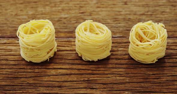 Roll of spaghetti on wooden table alt