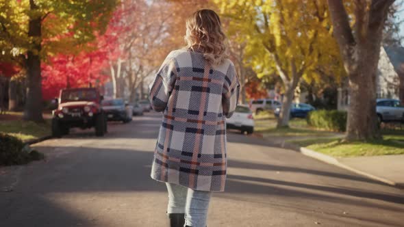 Slow Motion Woman Walking By Street with Colorful Vibrant Red and Golden Trees alt