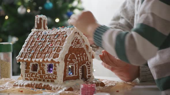 Little Boy with Mother Decorating Christmas Gingerbread House Together Family Activities and