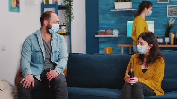 Joyfull Friends Sitting on Couch in Living Room During New Normal Party alt