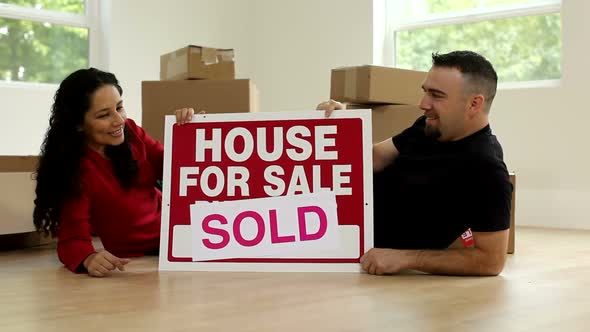 Couple in new home with sign alt